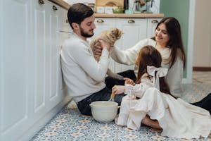 Family enjoying quality time in kitchen with their cat. Cozy indoor scene.